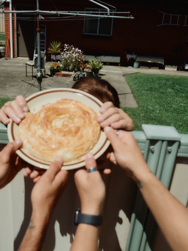 Yia Yia handing a pie over the fence